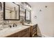 Rustic bathroom features a double vanity, wood paneling, and granite countertops at 12454 Antelope Trl, Parker, CO 80138