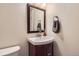 Charming half-bathroom featuring a stylish mirror and a sink with a mahogany cabinet at 12454 Antelope Trl, Parker, CO 80138