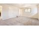 A bright bedroom offers neutral walls, plush carpet, and a window for natural light at 12454 Antelope Trl, Parker, CO 80138