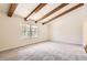 Bright, spacious living room with exposed wood beams, neutral carpet, and a large window offering pleasant views at 12454 Antelope Trl, Parker, CO 80138