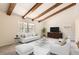Bright living room with exposed beams, large window and a comfortable seating area with elegant furniture at 12454 Antelope Trl, Parker, CO 80138