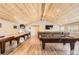 Spacious game room featuring a wood-paneled ceiling, pool table, shuffleboard, seating area, and a large mounted TV at 12454 Antelope Trl, Parker, CO 80138