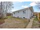 View of the side of a single-story home with a grassy backyard, pathway and a fenced area at 2455 E Yale Ave, Denver, CO 80210