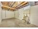 Unfinished basement with exposed ductwork, utility sink, and bright concrete flooring at 2455 E Yale Ave, Denver, CO 80210