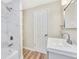 Brightly lit full bathroom, featuring new vanity, sink, fixtures, and tiled shower at 2455 E Yale Ave, Denver, CO 80210