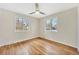 Bright bedroom featuring hardwood floors, fresh paint, a ceiling fan, and two windows at 2455 E Yale Ave, Denver, CO 80210