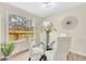 Bright dining area features a modern glass table, white chairs, and a large window overlooking the backyard at 2455 E Yale Ave, Denver, CO 80210