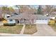 Aerial view of a charming single-story home with a well-maintained lawn and a large driveway at 2455 E Yale Ave, Denver, CO 80210