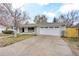 Single story home with a large driveway, attached two car garage, tidy lawn, and brick facade at 2455 E Yale Ave, Denver, CO 80210