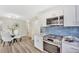 Modern kitchen features stainless steel appliances, white cabinets, and a stylish tile backsplash at 2455 E Yale Ave, Denver, CO 80210