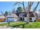 Beautifully landscaped front yard with healthy green grass and mature shade trees, showcasing home's exterior at 4970 S Chester St, Greenwood Village, CO 80111