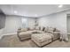 Finished basement with sectional and a patterned ottoman at 4970 S Chester St, Greenwood Village, CO 80111