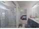 Elegant bathroom with a glass-enclosed shower, double vanity, and serene bedroom view at 6220 Waterman Way, Frederick, CO 80516