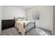 Simple bedroom with a metal bed frame, dresser, and a window well at 6220 Waterman Way, Frederick, CO 80516