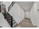 Bright entryway featuring wood floors, staircase with dark wood rails, and white trim at 6220 Waterman Way, Frederick, CO 80516