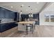 Spacious kitchen with dark blue cabinets, gray backsplash, stainless appliances, and a large island at 6220 Waterman Way, Frederick, CO 80516