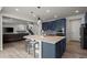 A spacious kitchen island offers seating, stylish lighting, and seamless connection to the living room at 6220 Waterman Way, Frederick, CO 80516