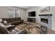Cozy living room showcasing a stone fireplace, plush sectional sofa, and soft rug at 6220 Waterman Way, Frederick, CO 80516
