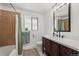 Bright bathroom featuring a modern vanity, tiled walls, and tub with shower at 421 Iola St, Aurora, CO 80010