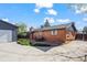 Brick home exterior with a spacious backyard, patio, detached garage, and well-maintained landscaping at 421 Iola St, Aurora, CO 80010