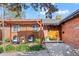 Inviting brick home with covered patio seating area and well-manicured landscaping, great for relaxing at 421 Iola St, Aurora, CO 80010