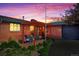 Charming brick home at dusk with a pergola-covered patio and well-maintained landscaping at 421 Iola St, Aurora, CO 80010