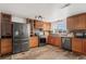 Modern kitchen with stainless steel appliances, wood cabinetry, and stylish backsplash, ready to cook at 421 Iola St, Aurora, CO 80010