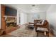 Bright living room with a cozy brick fireplace, stylish rug and comfortable, leather furniture at 421 Iola St, Aurora, CO 80010