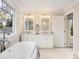 Bright bathroom features a soaking tub, double vanity, and large window with views at 1944 Hudson St, Denver, CO 80220