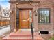Charming brick home featuring a stylish wood front door and updated lighting at 1944 Hudson St, Denver, CO 80220