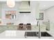 This light and airy kitchen features stainless steel appliances, marble counters, and light green cabinetry at 1944 Hudson St, Denver, CO 80220