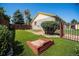 Landscaped backyard with green grass, red sand box, stone path and mature trees at 1030 S Fulton Ave, Fort Lupton, CO 80621