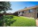 Beautifully landscaped backyard with green grass, patio, pergola, and mature tree at 1030 S Fulton Ave, Fort Lupton, CO 80621