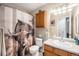 Bathroom with decorative shower curtain, vanity, medicine cabinet, and neutral walls at 1030 S Fulton Ave, Fort Lupton, CO 80621