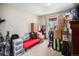Bedroom with a bright window, red daybed and packed belongings, ready for new memories at 1030 S Fulton Ave, Fort Lupton, CO 80621
