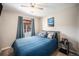 Cozy bedroom with blue bedding, neutral walls, ceiling fan, and natural light at 1030 S Fulton Ave, Fort Lupton, CO 80621
