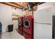 Finished laundry room with tile floors, red washer and dryer, and white refrigerator at 1030 S Fulton Ave, Fort Lupton, CO 80621
