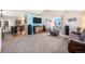 Open-concept living room featuring a vaulted ceiling, large TV, and seamless flow into the kitchen at 1030 S Fulton Ave, Fort Lupton, CO 80621