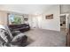 Bright living room with vaulted ceilings, large window, neutral carpet, and cozy furnishings at 1030 S Fulton Ave, Fort Lupton, CO 80621