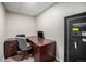 Functional home office space with dark wood desk, rolling chair, and safe at 1030 S Fulton Ave, Fort Lupton, CO 80621