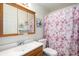 Bathroom featuring a classic wood vanity, toilet, and bathtub with floral curtain at 2782 S Ceylon St, Aurora, CO 80013