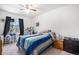 Bedroom features a window with curtains, dresser, and a blue and tan bedspread at 2782 S Ceylon St, Aurora, CO 80013