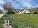 Exterior shot of a grassy lot for sale, sunny weather, and surrounding buildings at 5375 W 60Th Ave, Arvada, CO 80003
