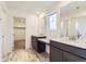 Bathroom featuring dual vanities, tile flooring, walk-in closet, and walk-in shower at 11030 Snowdon St, Parker, CO 80134