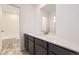 Bright bathroom featuring a white quartz countertop, dark cabinets, and a shower with white subway tile at 11030 Snowdon St, Parker, CO 80134