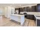 Modern kitchen with dark cabinets, stainless steel appliances, quartz countertops, and large island at 11030 Snowdon St, Parker, CO 80134