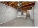 Partially finished basement featuring concrete flooring, white walls, open ceiling, and stairway access at 1027 Koss St, Erie, CO 80516