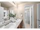 Bathroom with double sinks and a view of a neighboring bedroom and bathroom at 1027 Koss St, Erie, CO 80516