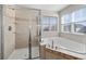 Bathroom featuring a glass shower and a soaking tub near a window at 1027 Koss St, Erie, CO 80516