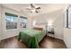 Bedroom with plush green bedspread, bedside tables, and large windows at 1027 Koss St, Erie, CO 80516